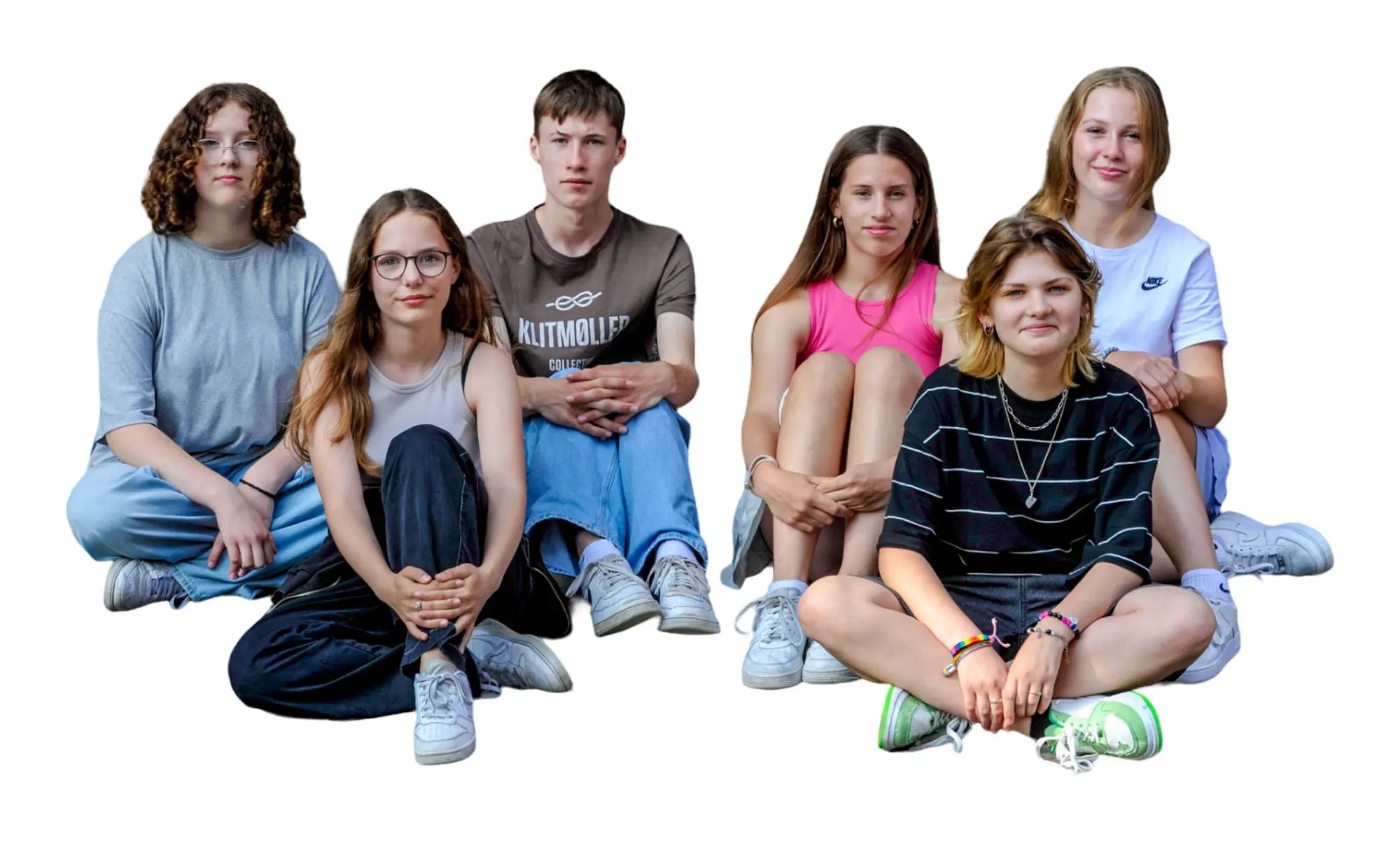 Sechs Jugendliche Knien auf einem Boden und sehen gespannt aus.